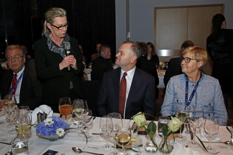 two women and two men sitting at a table with glasses