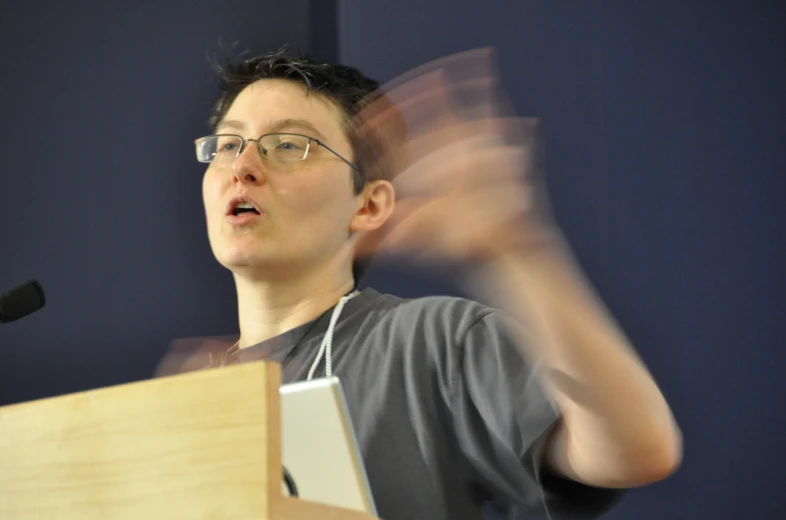 an asian man standing behind a podium giving a speech