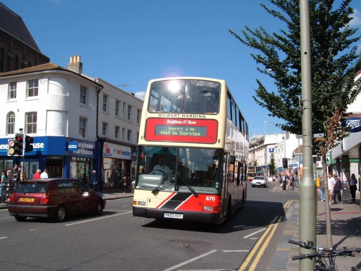 the two story bus is driving down the street