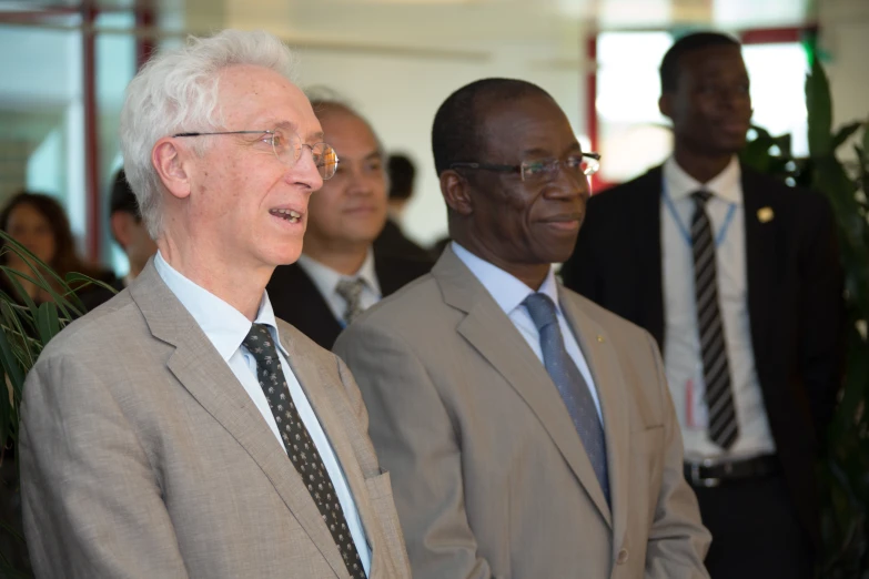 three men in suits and ties are standing side by side