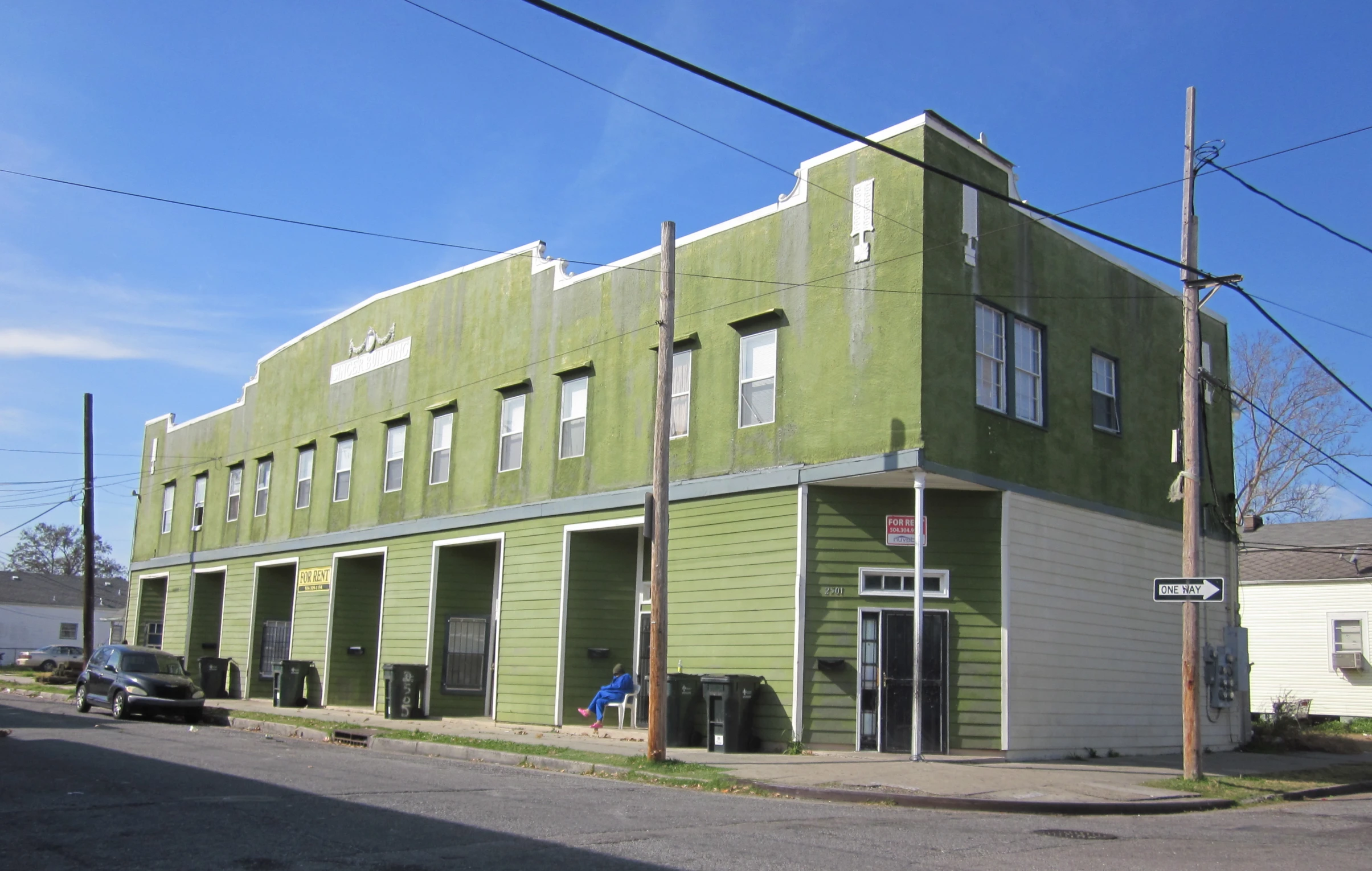 the green and gray building is next to a street