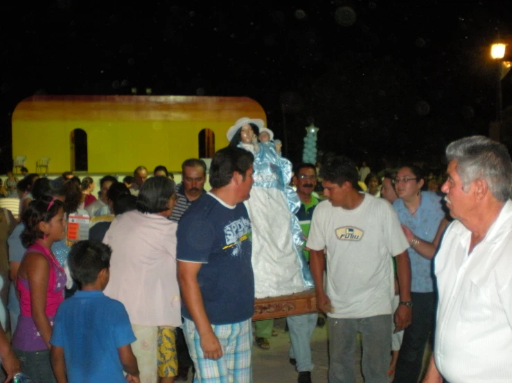 a group of people gathered outside with one man dressed in white