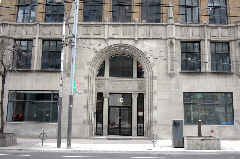 a large grey building has an arch doorway