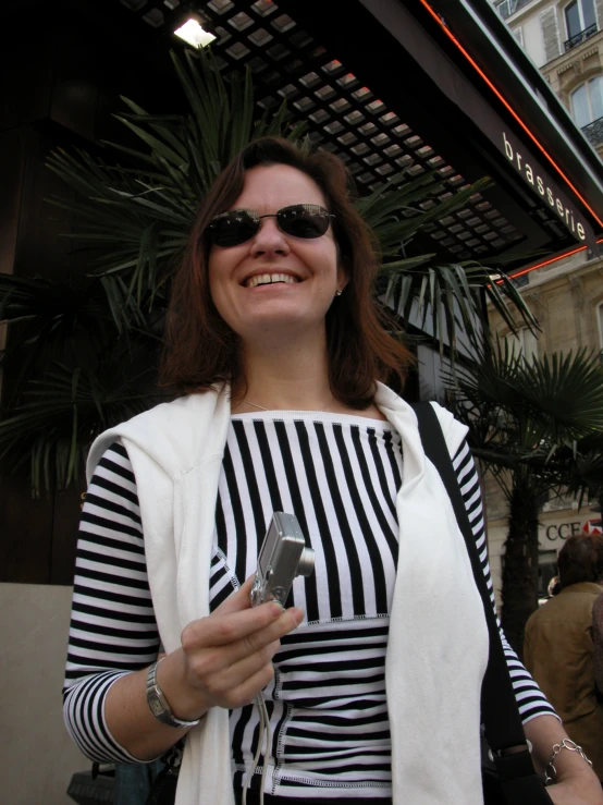 a woman smiling as she holds a cellular phone
