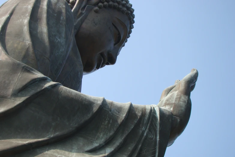 there is a statue of a buddha holding his hands in both ends