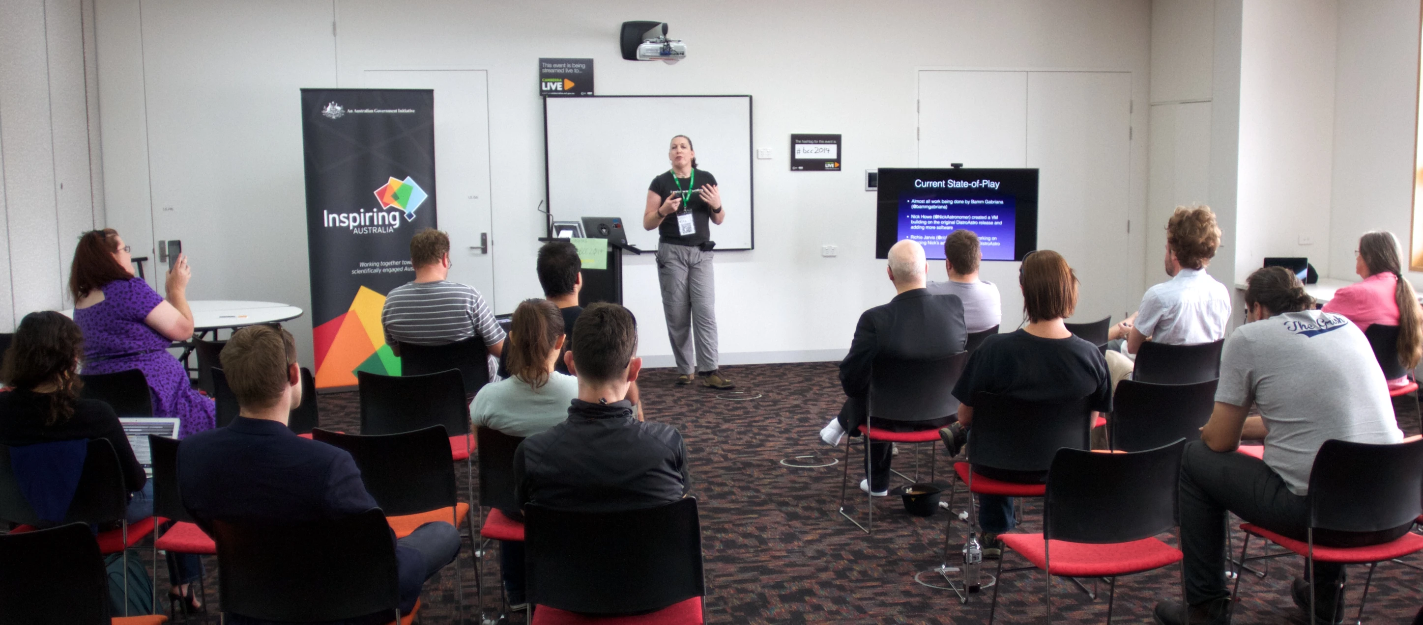 group of people attending to presentation in large room