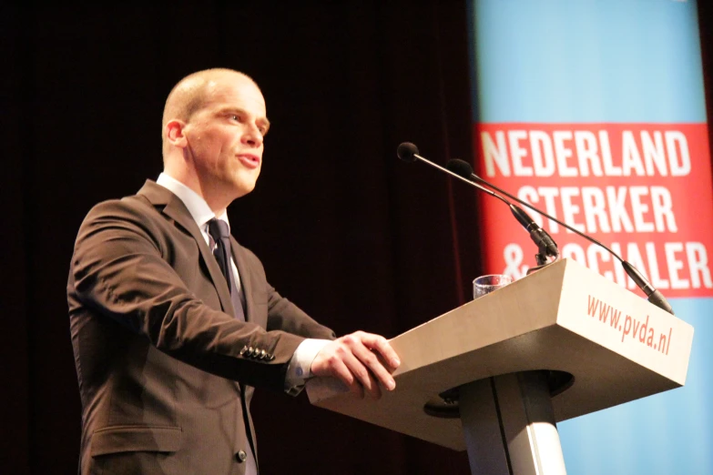 man standing behind a podium giving a speech