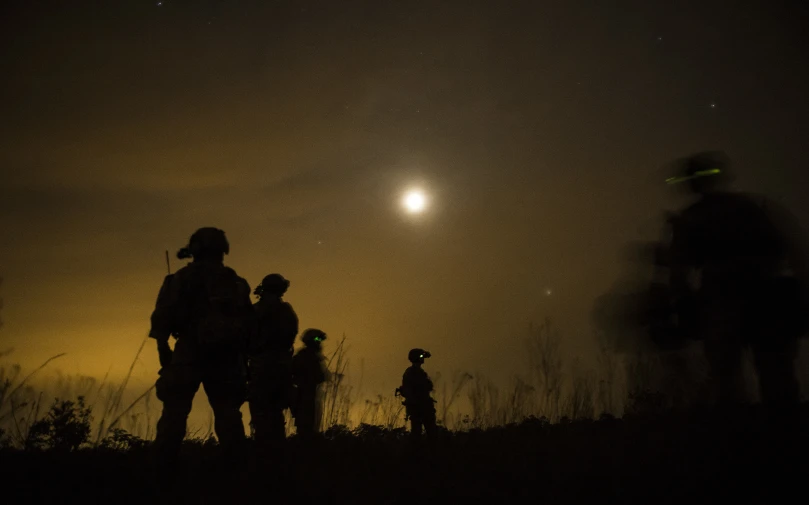 people standing on top of a hill in the night