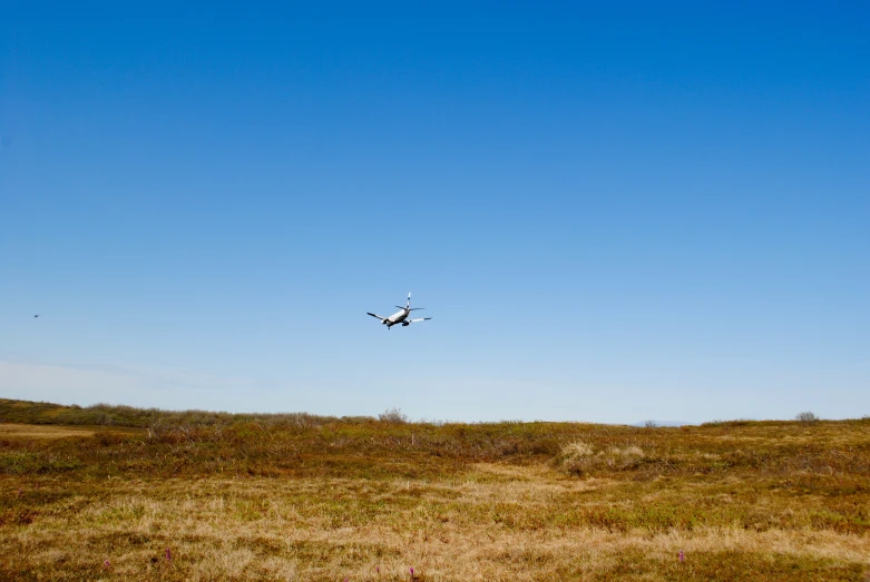 an airplane is flying in the sky over the ground