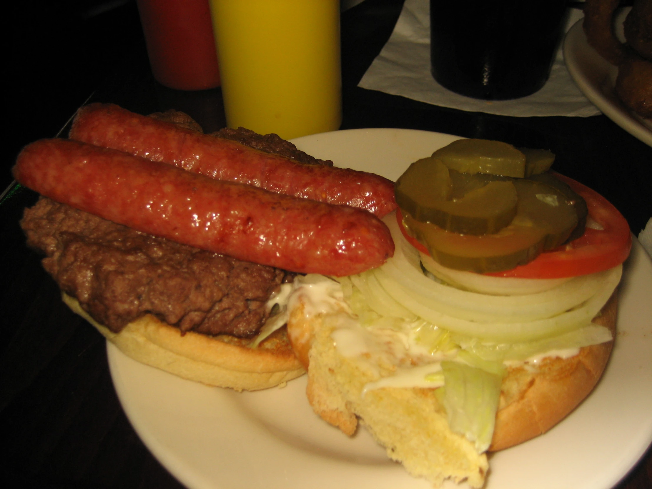 dogs with onions, pickles and a variety of sauces on a plate