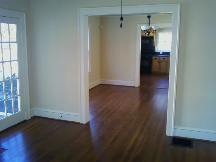 empty living room with wood floors and large windows