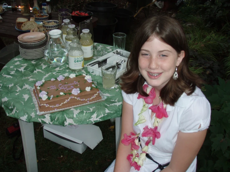a  in a green and white dress smiling with an iced cake