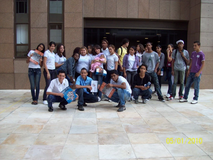 a group of young people posing for a po in front of a building