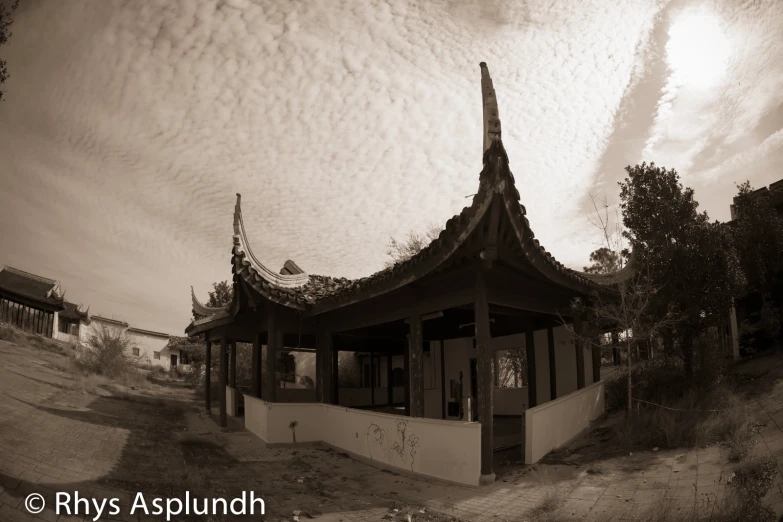 a white pavilion sits near a dirt path