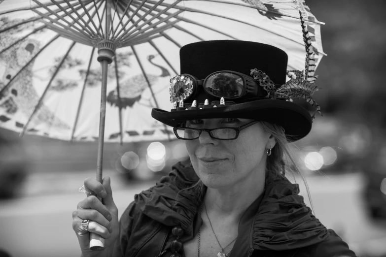 the woman is wearing an extravagant hat and carrying a parasol