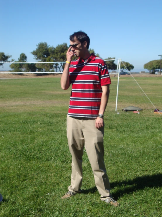 a man in a field on his cell phone