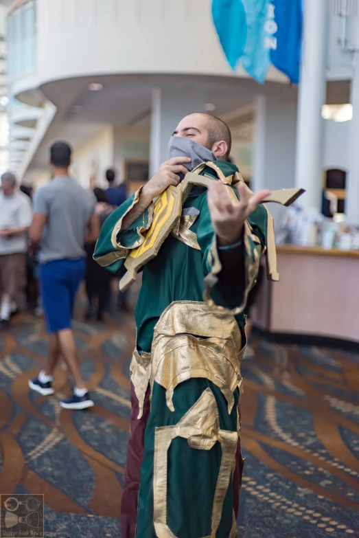 a man with a green and gold outfit holds onto a small white cat