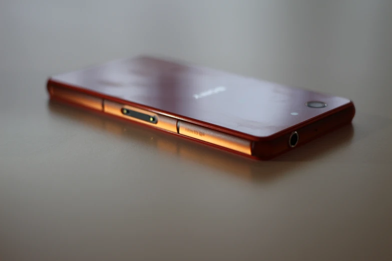 closeup of a gold colored cellphone on top of a table