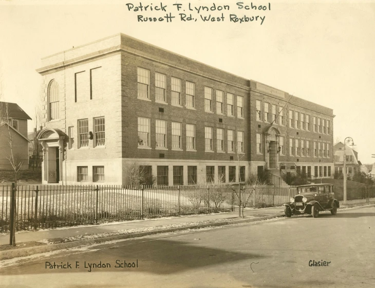 an old po of a car and a truck in front of a school