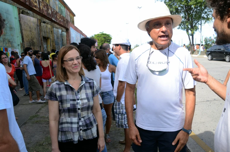 man on corner in white shirt pointing to a crowd