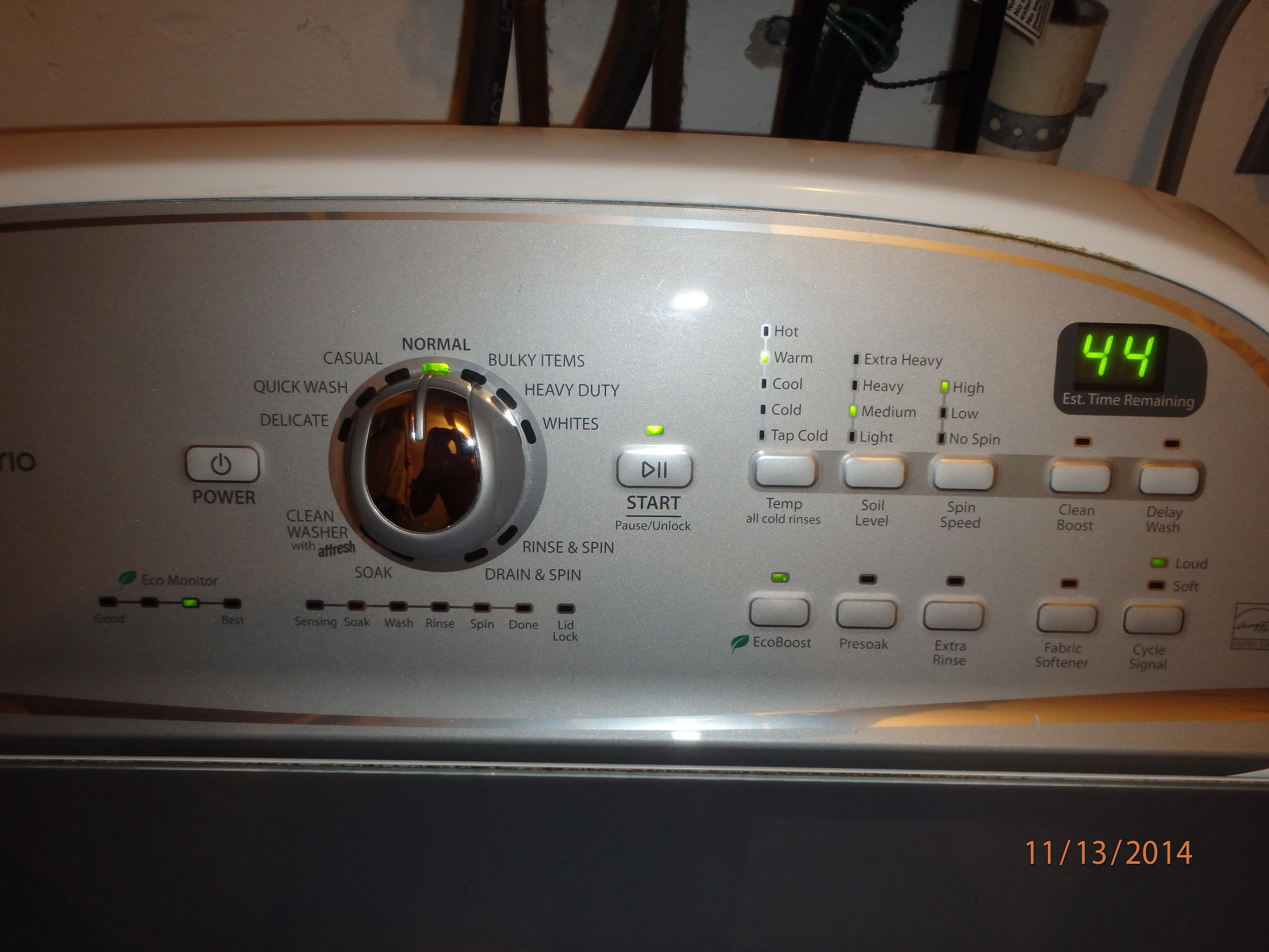 the clock on the front of a dryer has words written out in the lower left corner