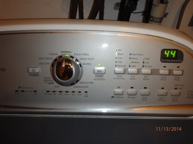 the clock on the front of a dryer has words written out in the lower left corner