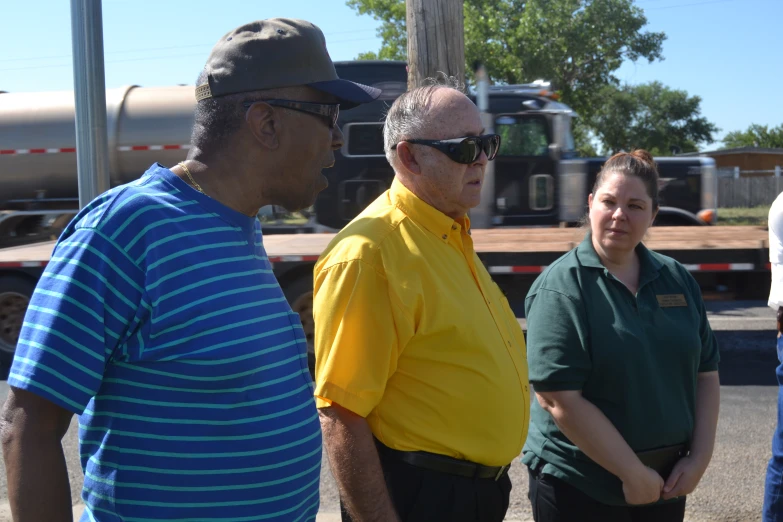 people standing next to each other in front of a semi truck