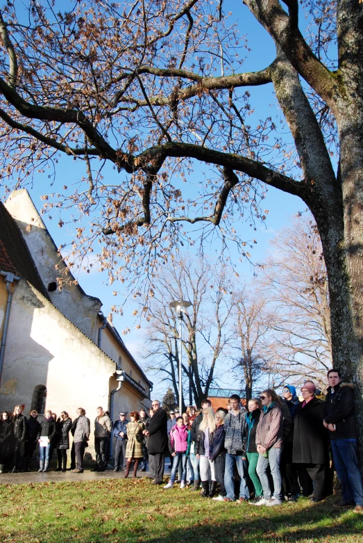 a group of people outside the church waiting in line for a ceremony