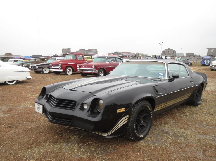 some vintage cars and old cars in a dirt lot