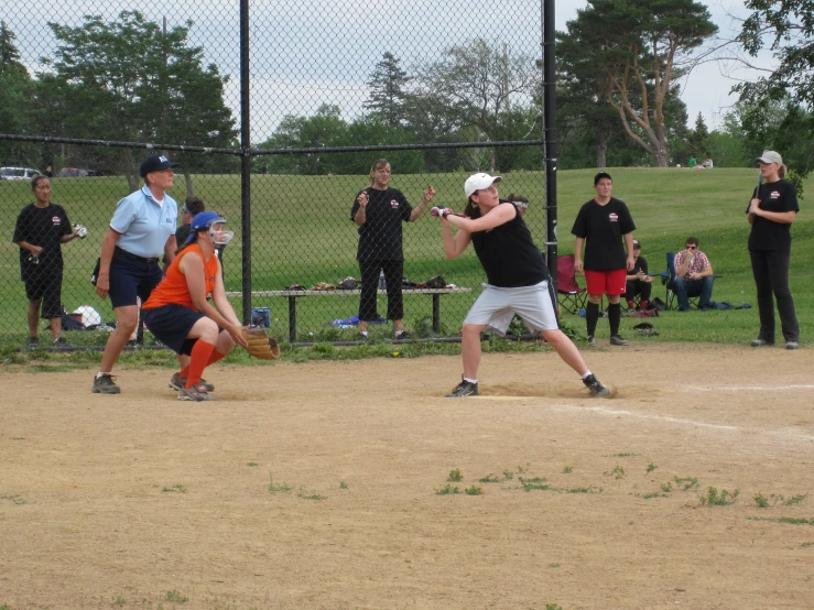 a group of people standing on a field playing baseball