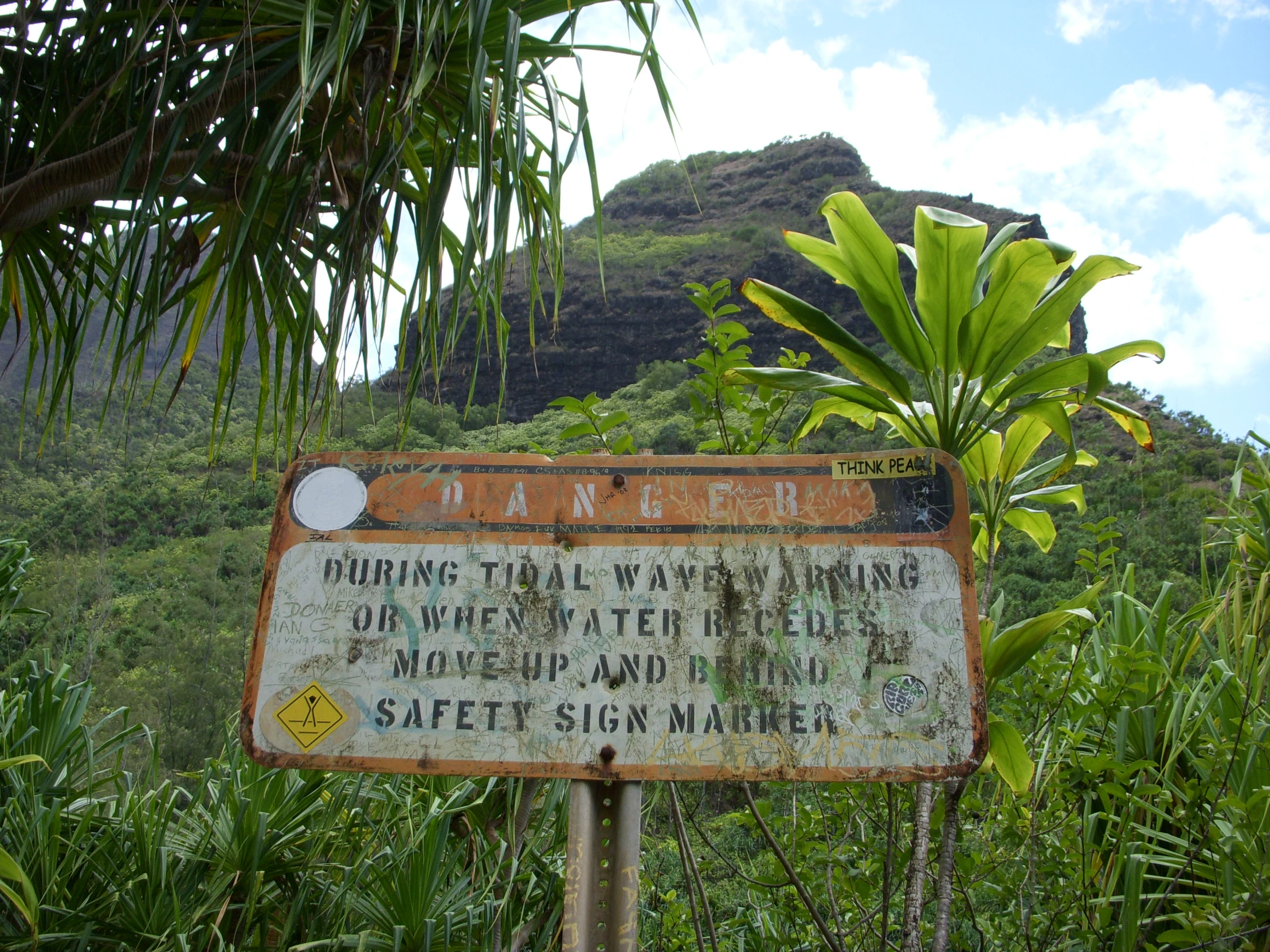 a large sign in front of some lush green trees