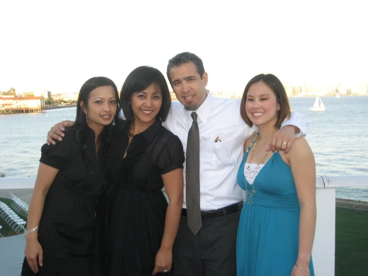 some people standing and posing by the water