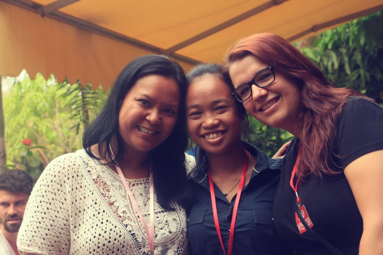 two women standing with a young woman at an event