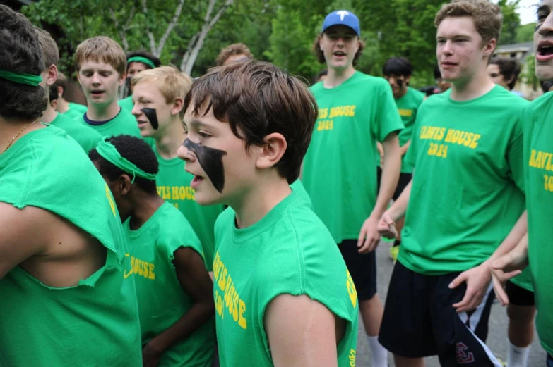 a group of young men with faces painted in yellow