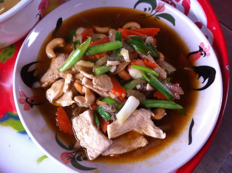 a large bowl of meat with carrots, celery and mushrooms