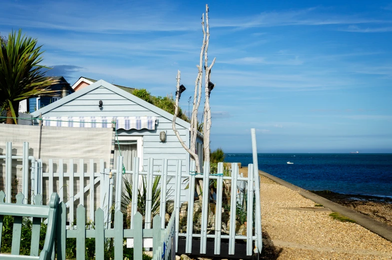 a fence next to a house and body of water