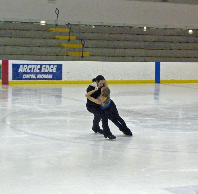a man and woman are skating on an ice rink
