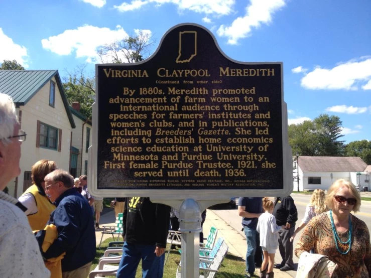 a group of people standing near a sign