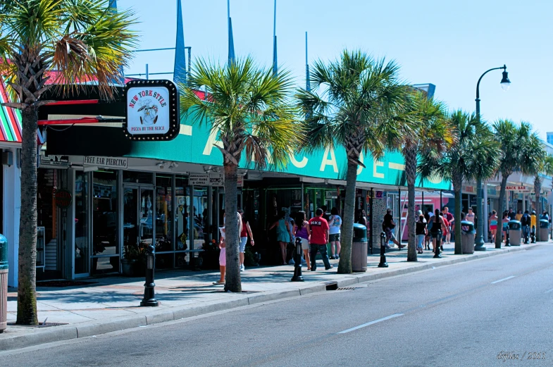 people stand outside of a row of stores