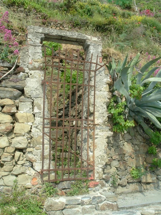 a gate with plants on it is next to a mountain