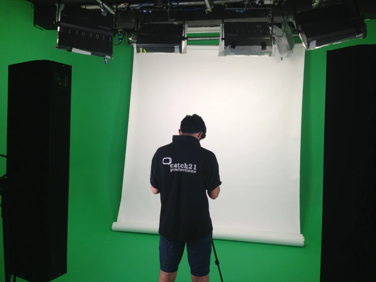 a man stands before a green screen in a pography studio