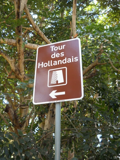 sign that says tour des holidays with trees in the background