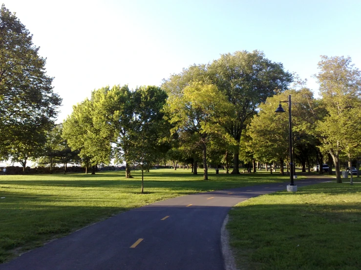 a long path is through the park in a wide open field