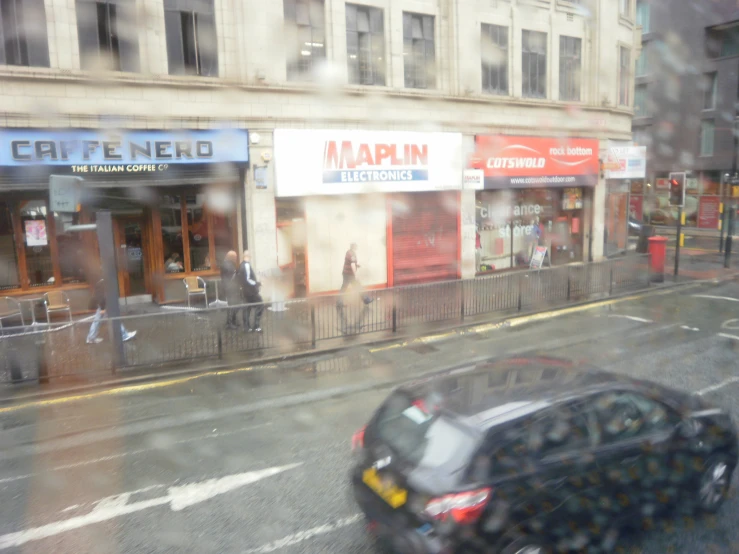 a car driving down a wet city street