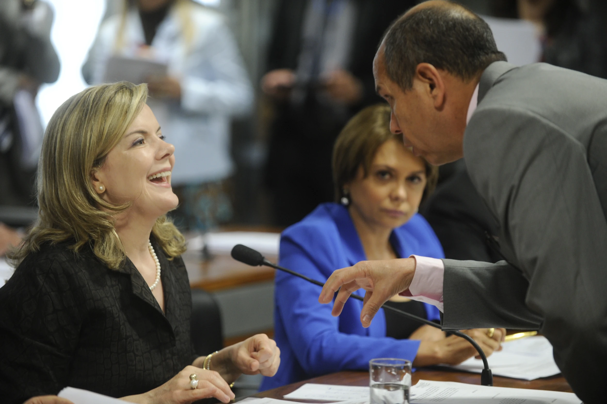 two people are sitting and one is holding a microphone