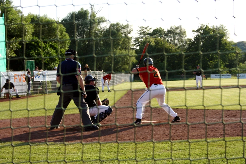 the catcher is preparing to catch a ball while the batter waits to swing