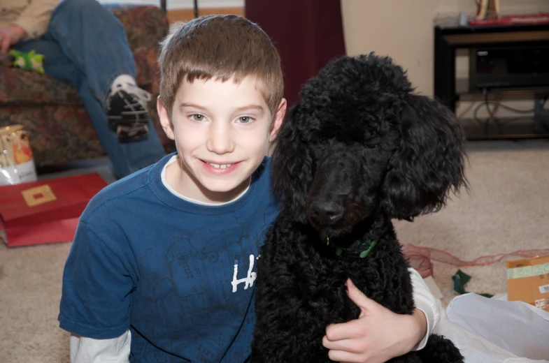 a  hugs his dog in the living room