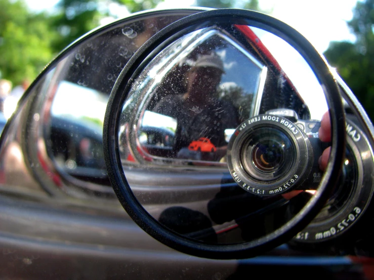 the reflection of the rear view mirror is seen through a car's side view mirror