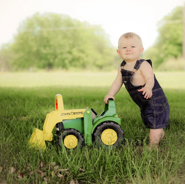 a young child playing with a toy tractor