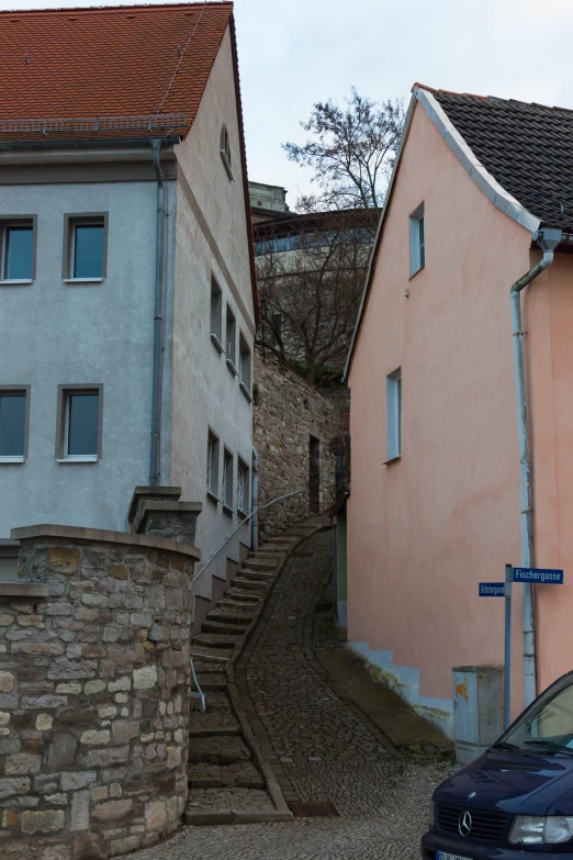 a cobble stone path between two pink houses